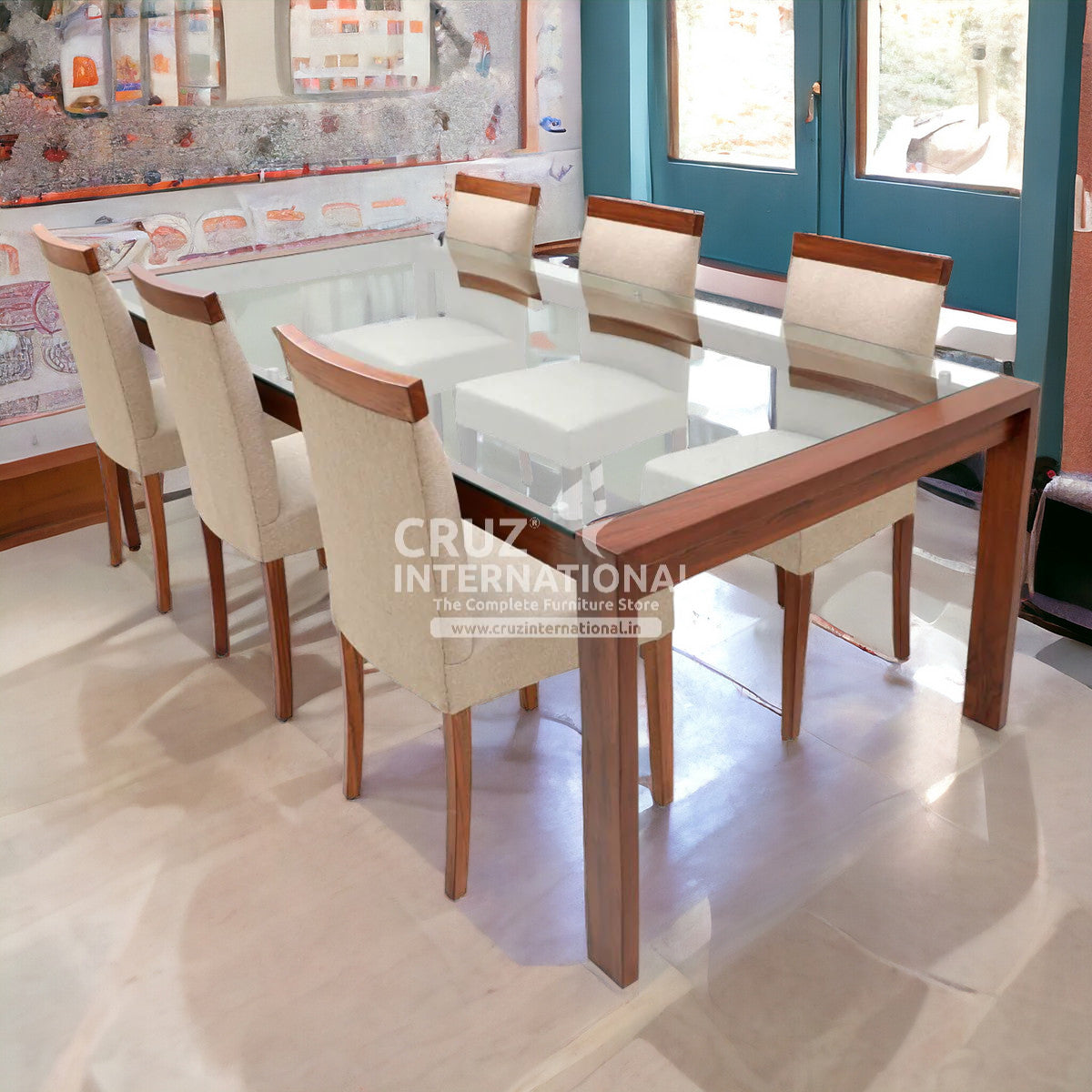 A wooden dining table with a clear glass top, accompanied by matching chairs with cushioned backrests and seats in a room with decorative wall decals.